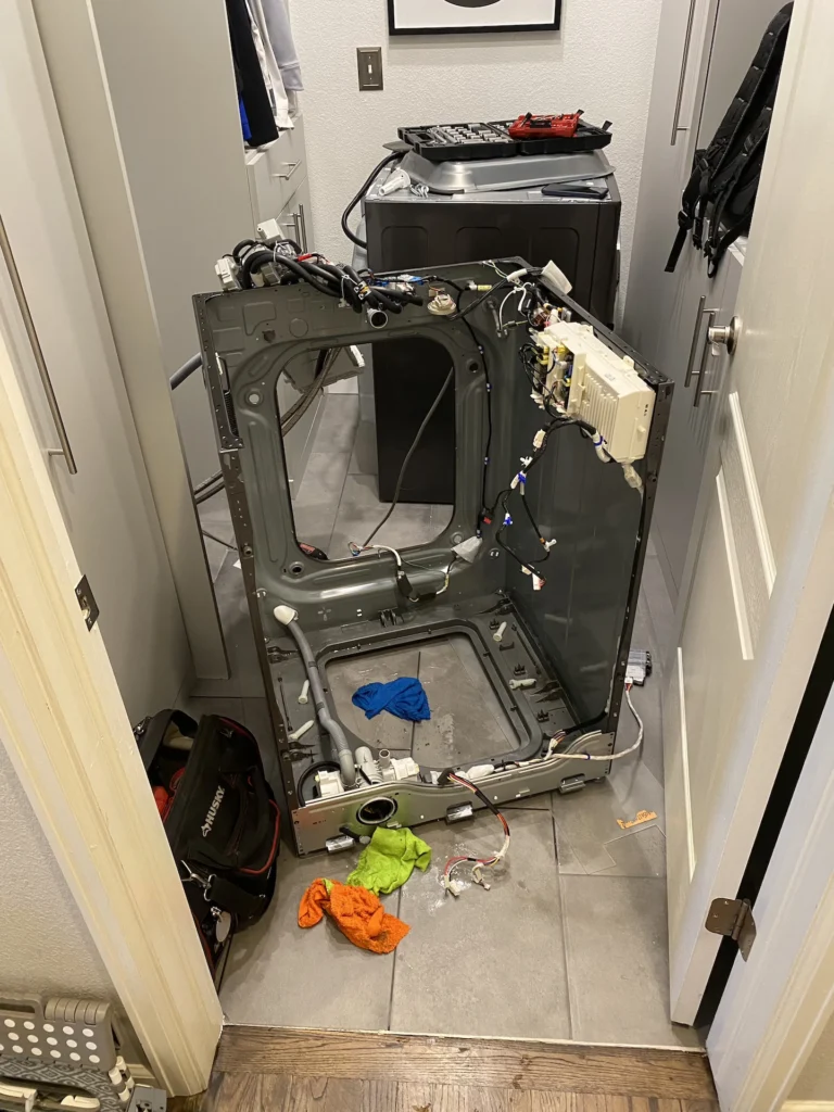 Washer repair technician diagnosing a washing machine in Denver, CO