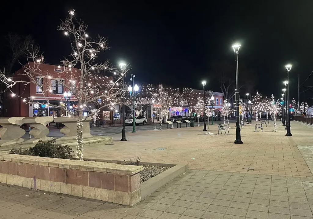 Downtown Arvada Colorado at night with illuminated trees and local businesses